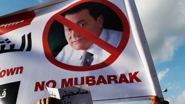 Protesters hold an anti-President Hosni Mubarak sign in Tahrir Square in Cairo.
