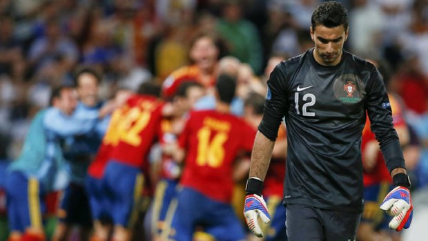 Portugal's goalkeeper Rui Patricio walks off the pitch as Spain's team celebrates its penalty shooout win in the European Championship semi-final in Donetsk.