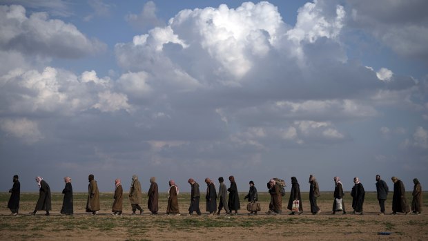Men on their way to be screened after being evacuated from former Islamic State territory near Baghouz, Syria.