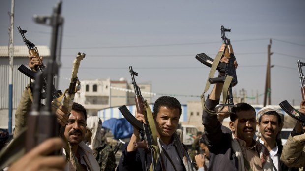 Houthi Shiite Yemeni raise their weapons during clashes in near the presidential palace in Sanaa.