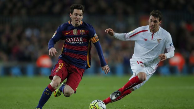 Barcelona's Lionel Messi, left, duels for the ball against Sevilla's Sebastian Cristoforo.
