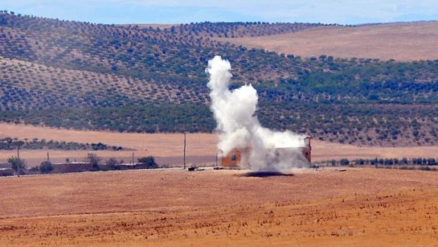 Smoke rises after Protection of the Kurdish People (YPG) fighters hit a target as they clash with possible Islamic State (IS) soldiers near the Syrian side of the Turkish border.