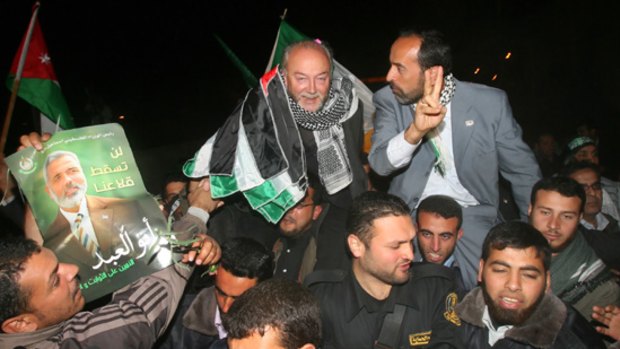 British MP George Galloway, centre top, is welcomed on arrival at Gaza's Rafah border after crossing from Egypt.