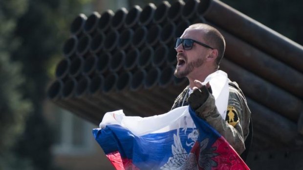 A pro-Russian rebel holds a Russian flag near Donetsk.
