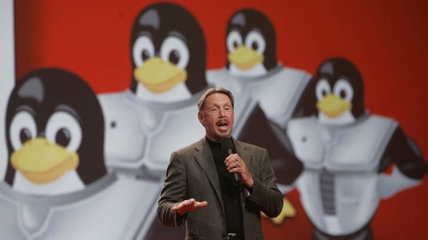Expansion: Oracle CEO Larry Ellison gestures in front of the Linux mascot of penguins during a keynote address. File