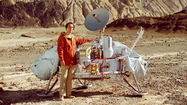 Dr. Carl Sagan poses with a model of the Viking lander in Death Valley, California.