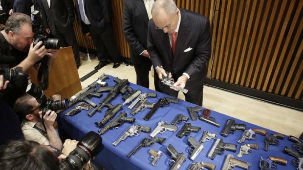 Deadly haul: New York Police Commissioner Raymond Kelly looks at some of the guns seized as part of gun smuggling between the Carolinas and New York.
