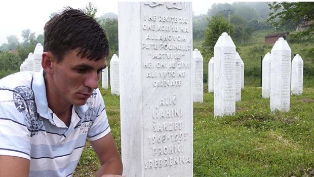 Memorial ...  Izudin Alic sits by the gravestone of his father who,  with the nearly 7000 other men and boys, was allegedly killed by Ratko Mladic’s forces in Srebrenica and thrown into a mass grave.