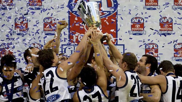 Conquering the peak: Geelong players celebrate after winning the 2011 grand final.