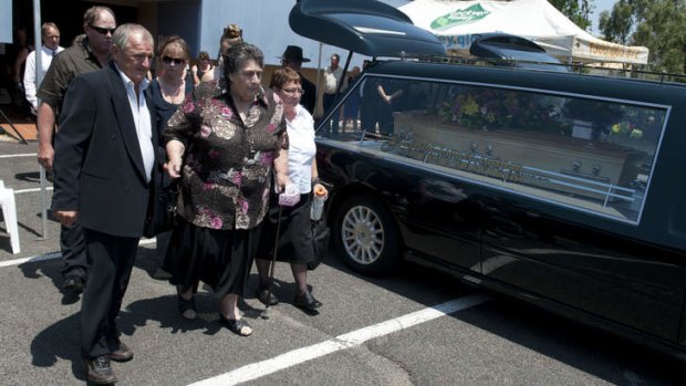Jean Bischoff (centre) is walked out by family members after the Funeral for Noelene and Yvana Bischoff in Gatton Baptist Church In Queensland.