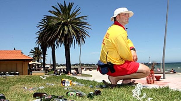 Lifeguard Matt Culka with some of the rubbish left on the St Kilda foreshore after New Year celebrations last January.