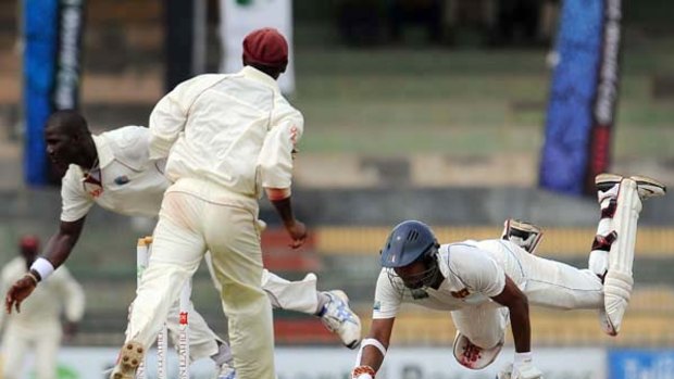 Sri Lanka captain Kumar Sangakkara dives to avoid being run out by his West Indies counterpart Darren Sammy (left).