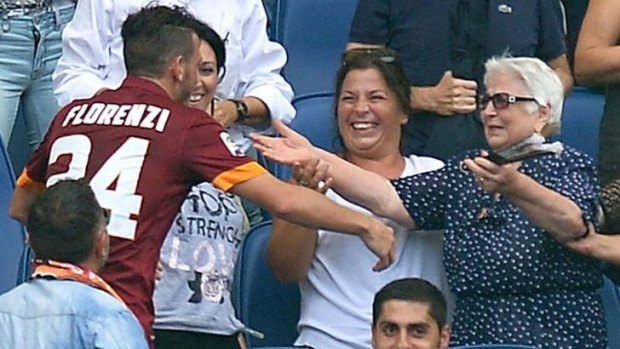 Booked: Alessandro Florenzi embraces his grandmother after scoring for Roma.