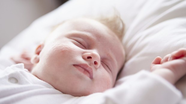 A baby girl sleeps ... the ACCC is reviewing safety standards for cots, strollers and bunk beds.