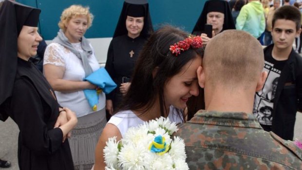 A Ukrainian soldier embraces his girlfriend during a welcome ceremony in the western city of Lviv as 146 soldiers return home after serving five-month missions battling pro-Kremlin insurgents in eastern Ukraine.