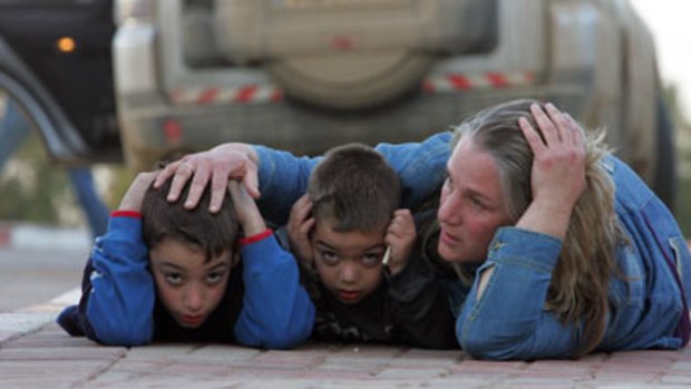 Mother's arms...an Israeli mother protects her children during a rocket-attack in the kibbutz of Kfar Aza on January 7.