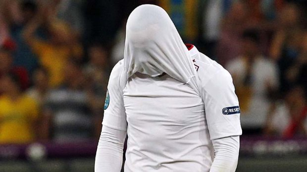 Can't watch ... England's Wayne Rooney covers his face after England lost to Italy on penalties.