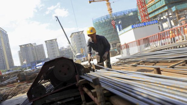 A worker processes reinforcing steel at a construction site in Beijing, China.
