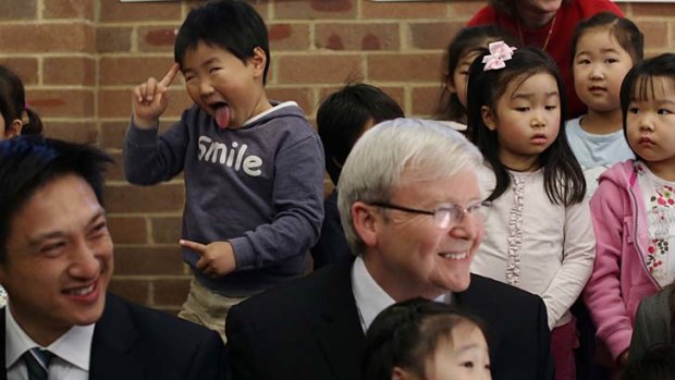 Photobomb: Joseph Kim poses behind Prime Minister Kevin Rudd at the Ryde Uniting Church in Sydney.