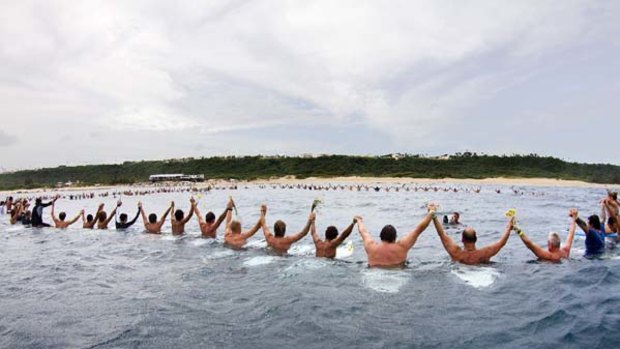 United in grief . . . surfers formed a chain at Middles Beach in Puerto Rico in November to honour three-time world champion Andy Irons, who died aged 32.