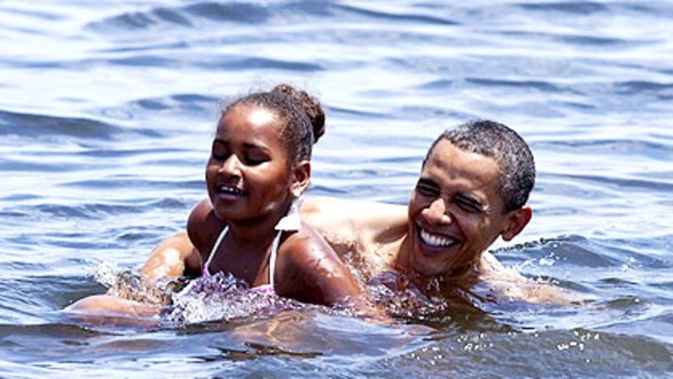 President Obama combines politics with pleasure, taking a dip with daughter Sasha off a Florida beach.