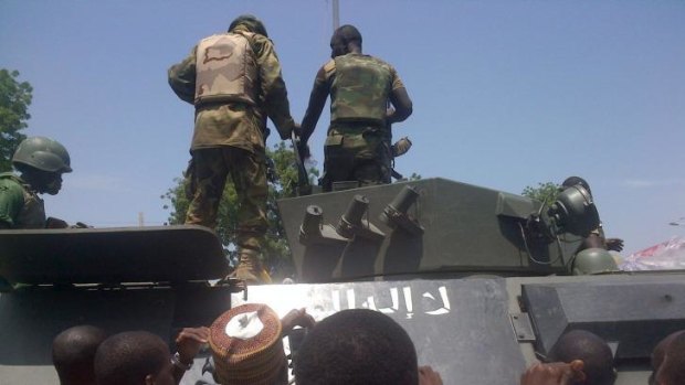 Troops stand on September 16, 2014 in Maiduguri on a armored personnel carrier (APC) recovered from Boko Haram insurgents in Konduga. Several Boko Haram insurgents have been killed in a fierce battle with Nigerian troops in a northeastern town near Maiduguri, 
