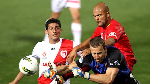 Heart goalkeeper Clint Bolton (right, in blue) makes a save during a clash with Adelaide United.