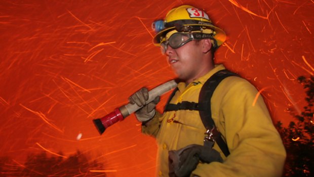 A US Forest Service firefighter is surrounded by flying embers near Santa Barbara.