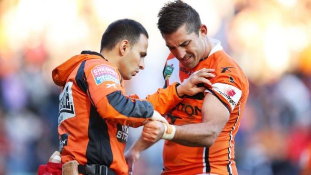 The end: Braith Anasta is attended to by a Tigers trainer during the clash with Penrith.