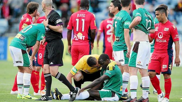 Floored: Jets star Emile Heskey on the ground following Nigel Boogaard's red card challenge at Adelaide.