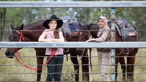 ''All the locals have been very friendly'' ... Kirra Rigg, 10, with the Indonesian animal husbandry student Safitri, 20, at Lakefield Station in the Northern Territory.