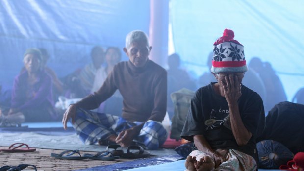 Villagers sit in a temporary shelter in Bali, Indonesia, on Saturday.