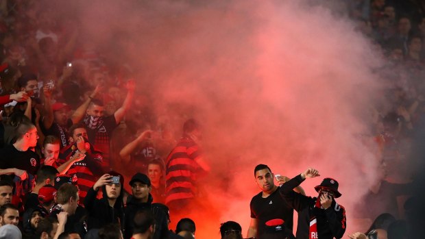 Fan flare: Wanderers fans look on as a flare is lit during the loss to Sydney FC.