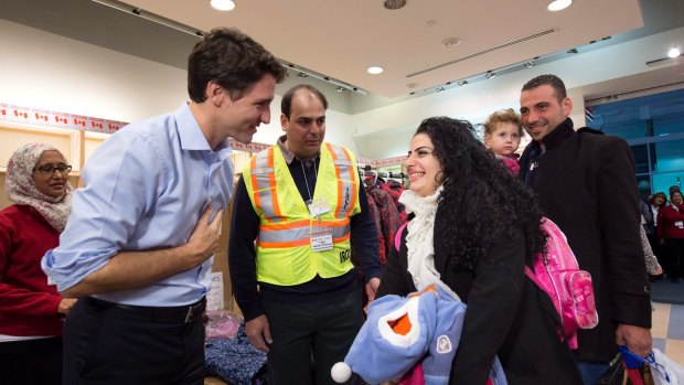 Canadian PM Justin Trudeau, left, welcomes the Jamkossian family from Syria, at Pearson International airport,Toronto, in December. Canada has resettled 40,000 Syrian refugees since Trudeau came to power.