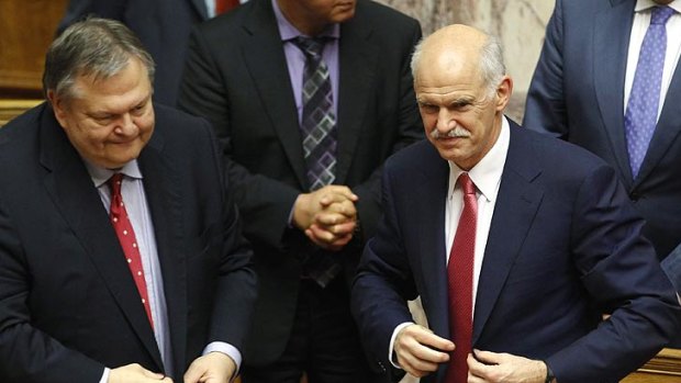 Greece's PM George Papandreou (R) and Finance minister Evangelos Venizelos smile after winning a vote of confidence.