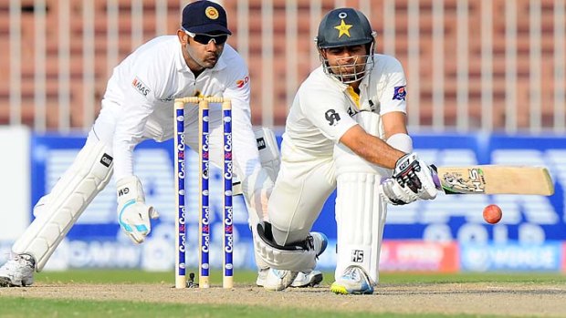 Pakistan's Ahmed Shehzad plays a reverse sweep as Sri Lankan wicketkeeper Prasanna Jayawardene watches on the third day of the final Test in Sharjah.