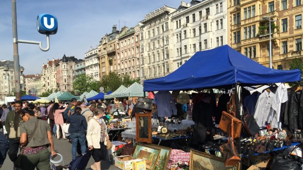 Trestle tables are piled high with household goods, clothes and art at the Vienna flea market. 