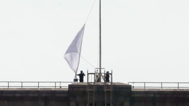 Two large American flags atop the Brooklyn Bridge were replaced during the night with white banners.