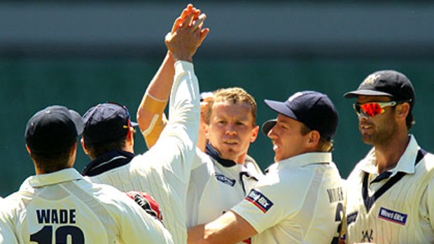 Peter Siddle is congratulated by teammates after taking a wicket in Victoria's clash with Tasmania yesterday.