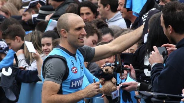 Chris Judd signs autographs for adoring fans after training.
