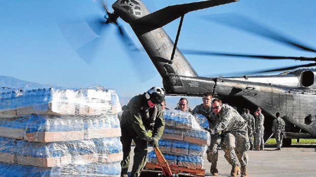 Help at hand ... US Army soldiers unload supplies from a US Navy helicopter at the Port-au-Prince airport yesterday.