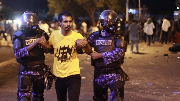 Maldives police detain an opposition supporter during a protest demanding Maldives President Yameen Abdul Gayoom resign and jailed ex-president Mohamed Nasheed be freed.
