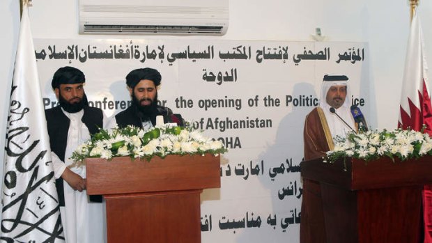 Defiant: The Taliban's Mohammed Naim (centre) and Qatari official Ali bin Fahd al-Hajri (right) in front of the controversial banner.