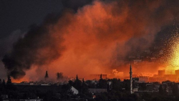 The battle rages ... Smoke and flames rise following an explosion in the Syrian town of Kobane.