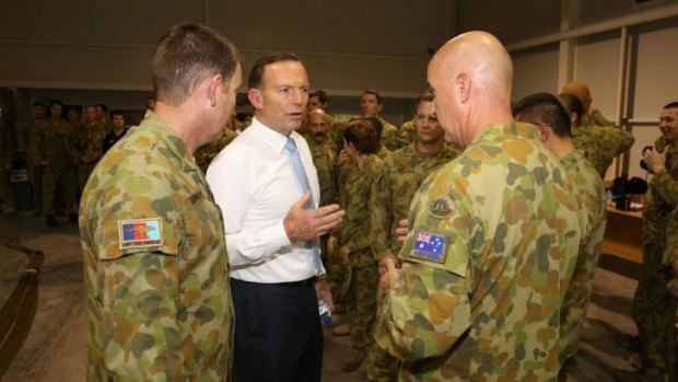 Prime Minister Tony Abbott at Al Minhad in the UAE. He has hosed down claims an Australian C-130 was shot at while on an aid drop in northern Iraq.