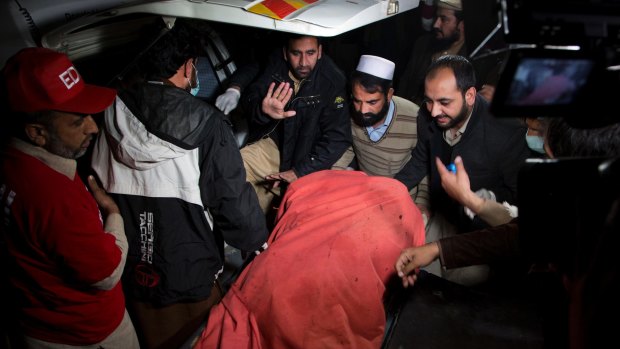 Pakistani volunteers move remains of plane crash victims to a mortuary at a hospital, in Abbottabad.