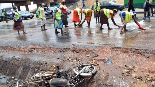 Week of violence ... Nigerian workers clean the site of a bomb blast in Abuja ripped through a packed bus station killing at least 75 and injuring 141. The explosion was blamed on Islamic extremist group Boko Haram.