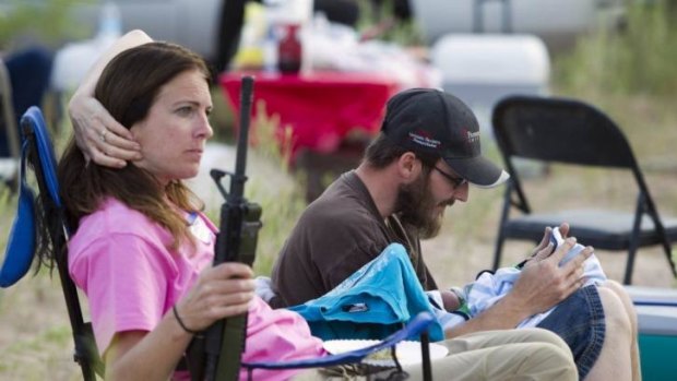 Highly armed family outing ... Chris Shelton of Las Vegas interacts with his 1-week-old son as his mother, Shelley Shelton, holds his automatic rifle during a Bundy family 'Patriot Party' near Bunkerville.