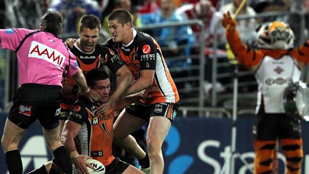 Stars and Stripes ... Chris Heighington scores a try against St George Illawarra on Friday night, earning instant congratulations from teammates and Stripes, the team mascot.