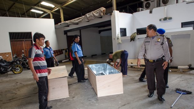 Workers from Abadi Funeral Homes prepare two wooden boxes to carry the coffins of Myuran Sukumaran and Andrew Chan home to Australia.